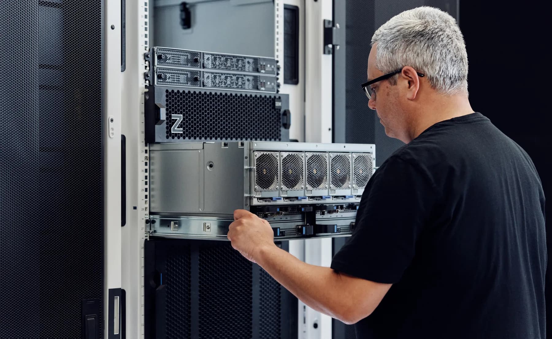 Technician sliding a fan-cooled IBM Z drawer into a rack-mount IBM z17 system